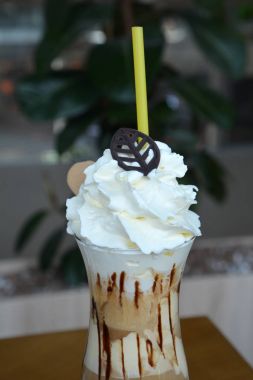 Bir cam bardak krem şanti ile lezzetli buzlu kahve.