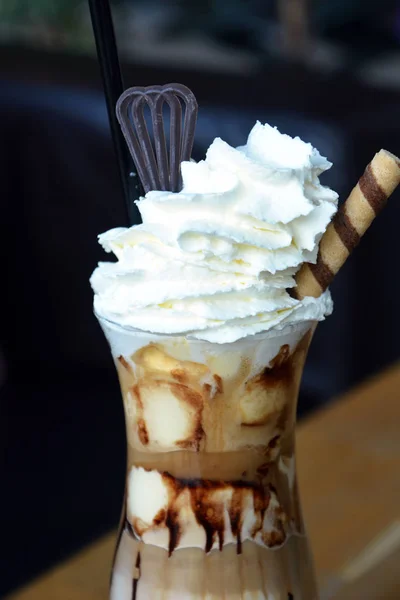 Delicious iced coffee with whipped cream on a glass cup.