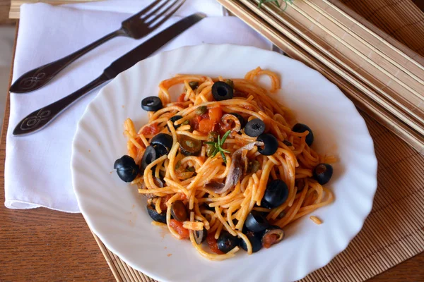 テーブルの上にボウルにアンチョビのおいしいイタリアン パスタ スパゲッティ. — ストック写真