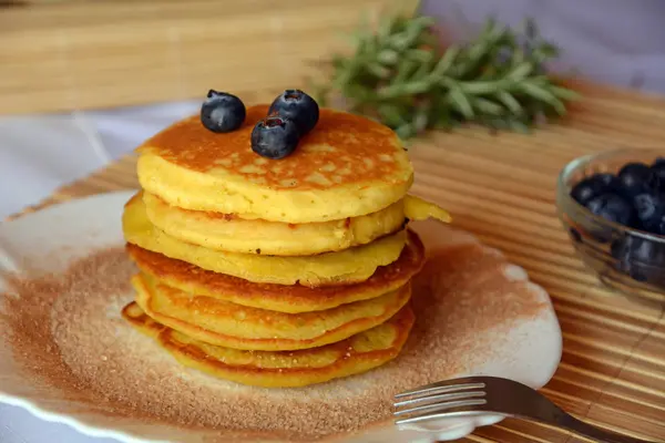 Stapel süßer Pfannkuchen mit frischen Blaubeeren und Zimtzucker auf einem Teller. — Stockfoto