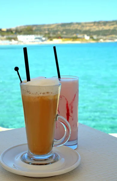 Milkshake feito de morango fresco maduro e café gelado em um fundo do mar . — Fotografia de Stock