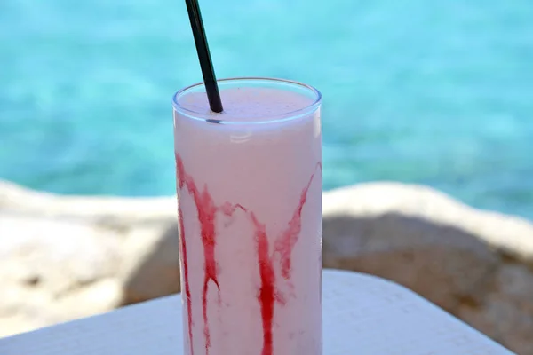 Milkshake feito de morango maduro fresco em um fundo do mar . — Fotografia de Stock