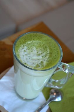 Ahşap bir masa cam bardakta Matcha latte yeşil Japon çay.