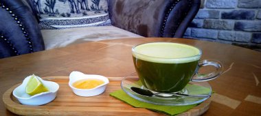 Ahşap bir masa cam bardakta Matcha yeşil çay.