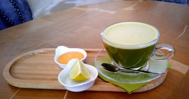 Ahşap bir masa cam bardakta Matcha yeşil çay.