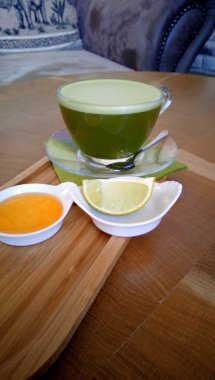 Ahşap bir masa cam bardakta Matcha yeşil çay.