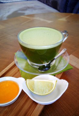 Ahşap bir masa cam bardakta Matcha yeşil çay.