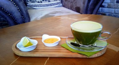 Ahşap bir masa cam bardakta Matcha yeşil çay.