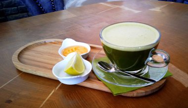 Ahşap bir masa cam bardakta Matcha yeşil çay.