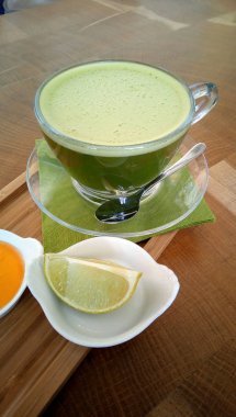 Ahşap bir masa cam bardakta Matcha yeşil çay.