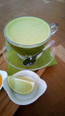 Ahşap bir masa cam bardakta Matcha yeşil çay.