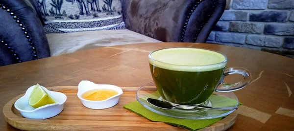 Ahşap bir masa cam bardakta Matcha yeşil çay.