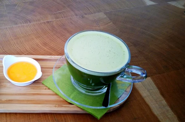 Ahşap bir masa cam bardakta Matcha yeşil çay.