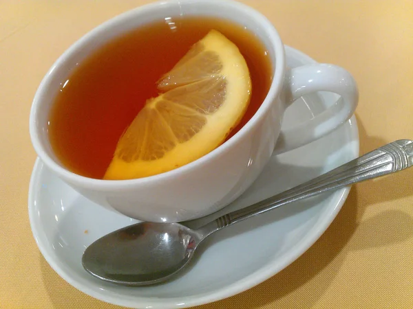 Verter té saludable. Té caliente en una taza en una mesa de madera . — Foto de Stock