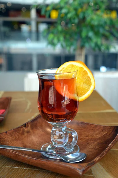 Sağlıklı çay dökme. Ahşap bir masa cam bardakta sıcak siyah çay. 