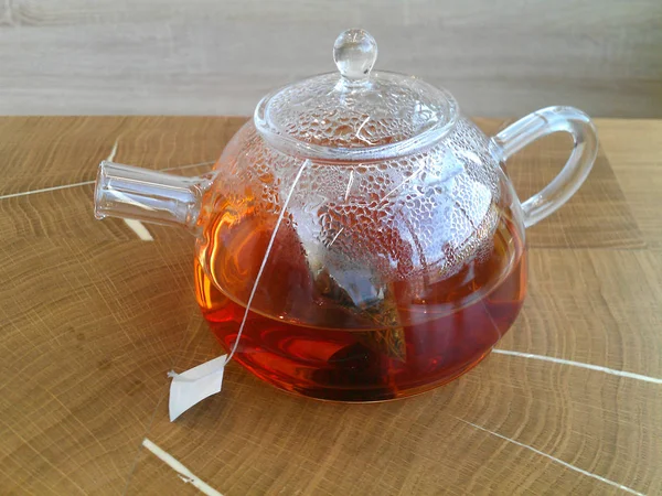 Chá quente verde em um bule de chá em um fundo de madeira . — Fotografia de Stock