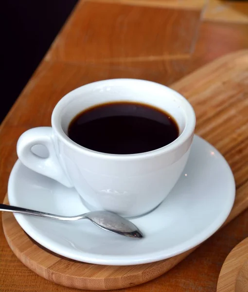 Caffè nero su una tazza su un tavolo di legno . — Foto Stock