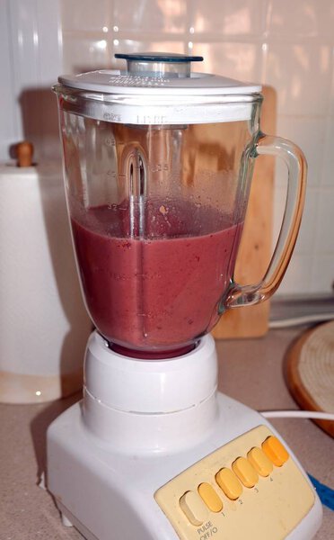 Preparation of fresh healthy blueberry and papaya smoothie on a mixer. 