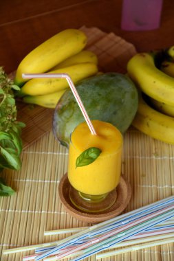 Taze sağlıklı mango ve muz güler yüzlü bir cam. Organik içki.