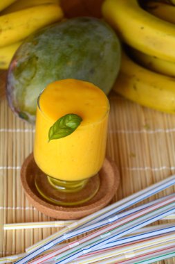 Taze sağlıklı mango ve muz güler yüzlü bir cam. Organik içki.