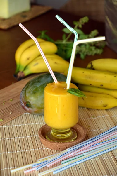 Taze sağlıklı mango ve muz güler yüzlü bir cam. Organik içki.