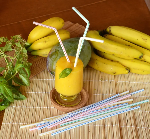 Taze sağlıklı mango ve muz güler yüzlü bir cam. Organik içki.