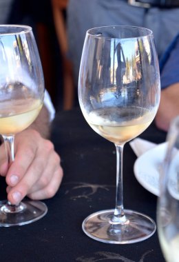 Bir restoran siyah bir arka planda beyaz şarap gözlük ile kutlama.