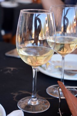 Bir restoran siyah bir arka planda beyaz şarap gözlük ile kutlama.