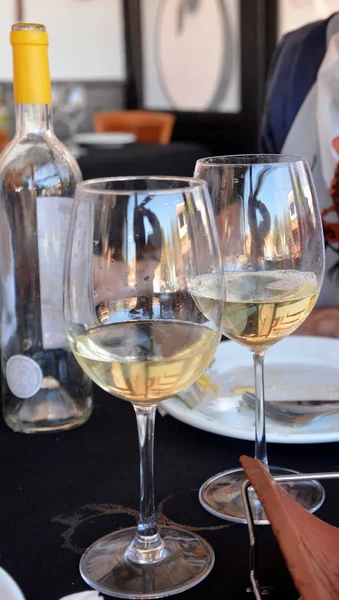 Bir restoran siyah bir arka planda beyaz şarap gözlük ile kutlama.