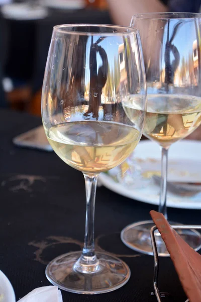 Bir restoran siyah bir arka planda beyaz şarap gözlük ile kutlama.