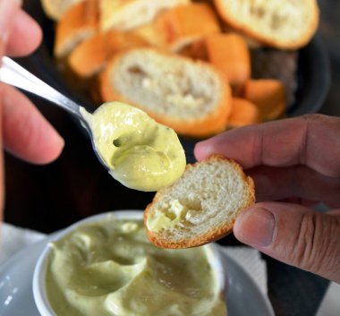 Bir el üzerinde taze bir ekmek alioli sosu koyuyor. İspanyol yemeği.