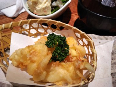 Japon derin kızarmış peynir bir sepet bir restoran tablo üzerinde sopa.