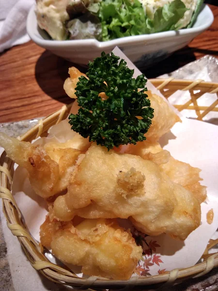 Japanese deep fried cheese sticks  on a basket on a restaurant table.