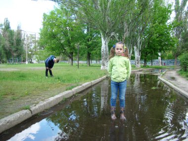 Çocuk su birikintileri gidiyor