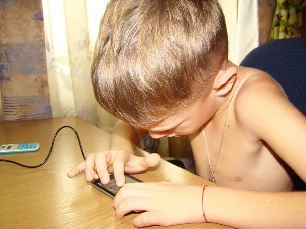 Uma criança brincando ao telefone — Fotografia de Stock