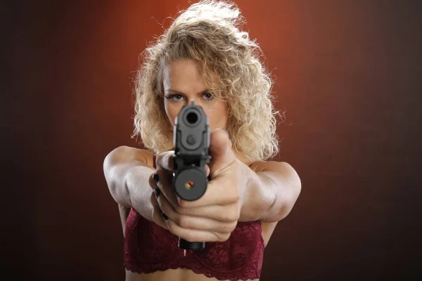 Fit blonde carries a semi-automatic pistol