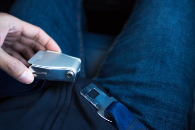 Araba kullanırken güvenlik için uçakta bir kemer. Kişi bel kemerini uçağın kalkması ya da inmesi için ayarlar. 