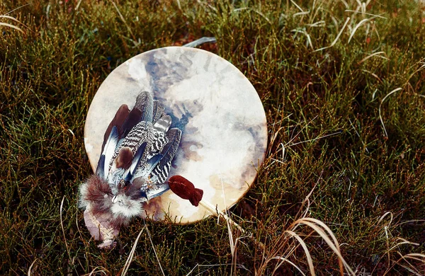 Tambor xamânico e penas xamânicas na ganga. — Fotografia de Stock