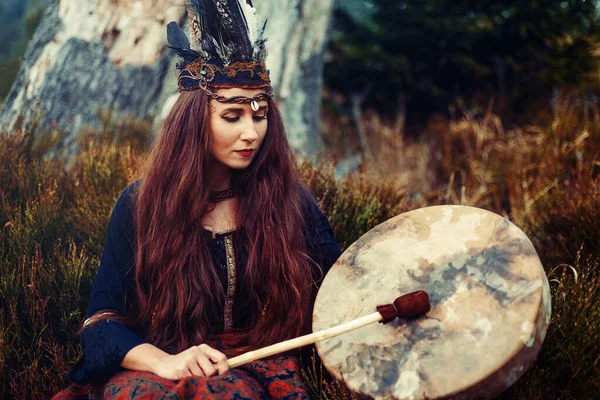 Beautiful shamanic girl playing on shaman frame drum in the nature. — Stock Photo, Image