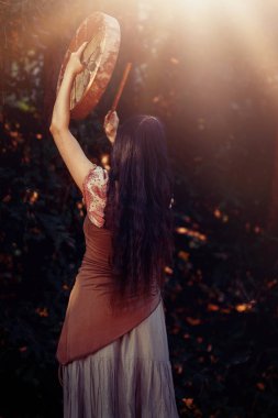 Şaman çerçeveli davul çalan güzel bir şaman kız..