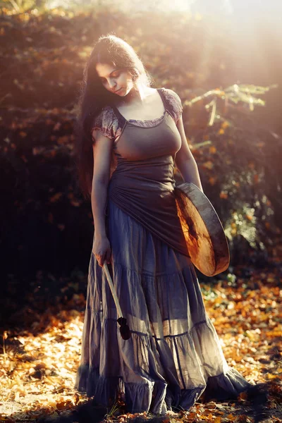 Beautiful shamanic girl playing on shaman frame drum in the nature. — Stock Photo, Image