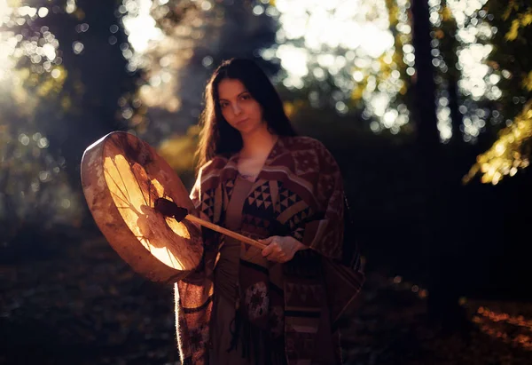 Красивая шаманская девушка, играющая на барабане шамана на природе. — стоковое фото