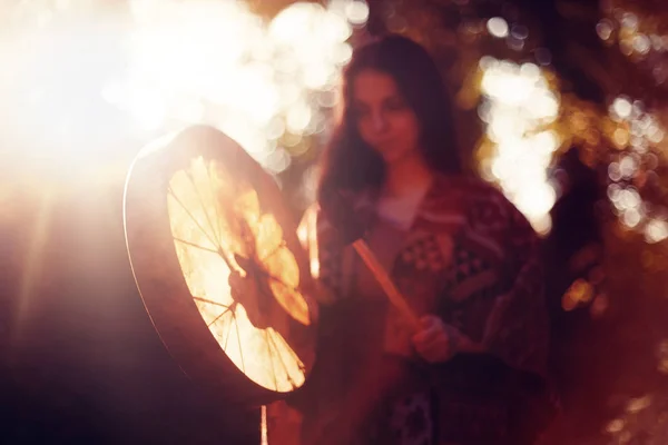 Beautiful shamanic girl playing on shaman frame drum in the nature. — Stock Photo, Image