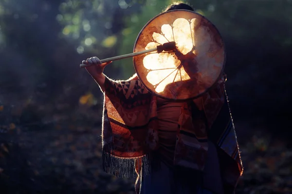 Beautiful shamanic girl playing on shaman frame drum in the nature. — Stock Photo, Image