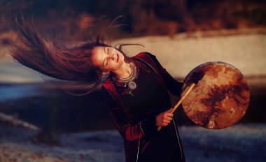 Şaman çerçeveli davul çalan güzel bir şaman kız..