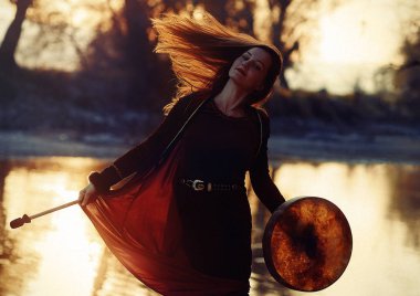 Şaman çerçeveli davul çalan güzel bir şaman kız..