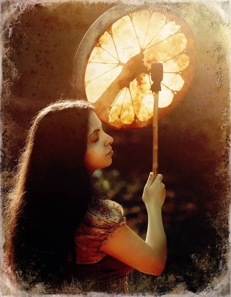 Krásná šamanská dívka hrající na šamanský rám buben v přírodě, starý fotografický efekt. — Stock fotografie