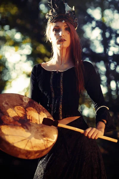 Mooi sjamanistisch meisje spelen op sjamaan frame drum in de natuur. — Stockfoto