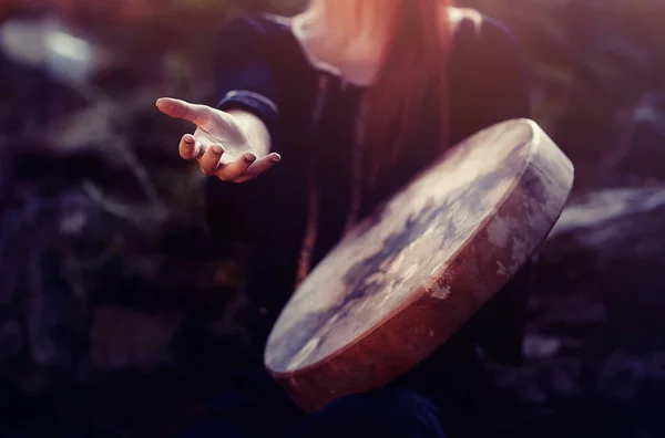 Mooi sjamanistisch meisje spelen op sjamaan frame drum in de natuur. — Stockfoto