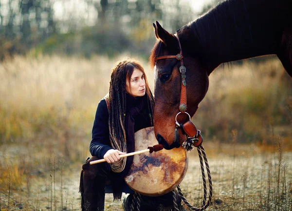 Ung fruktad flicka med sin häst och schamanisk ram trumma. — Stockfoto